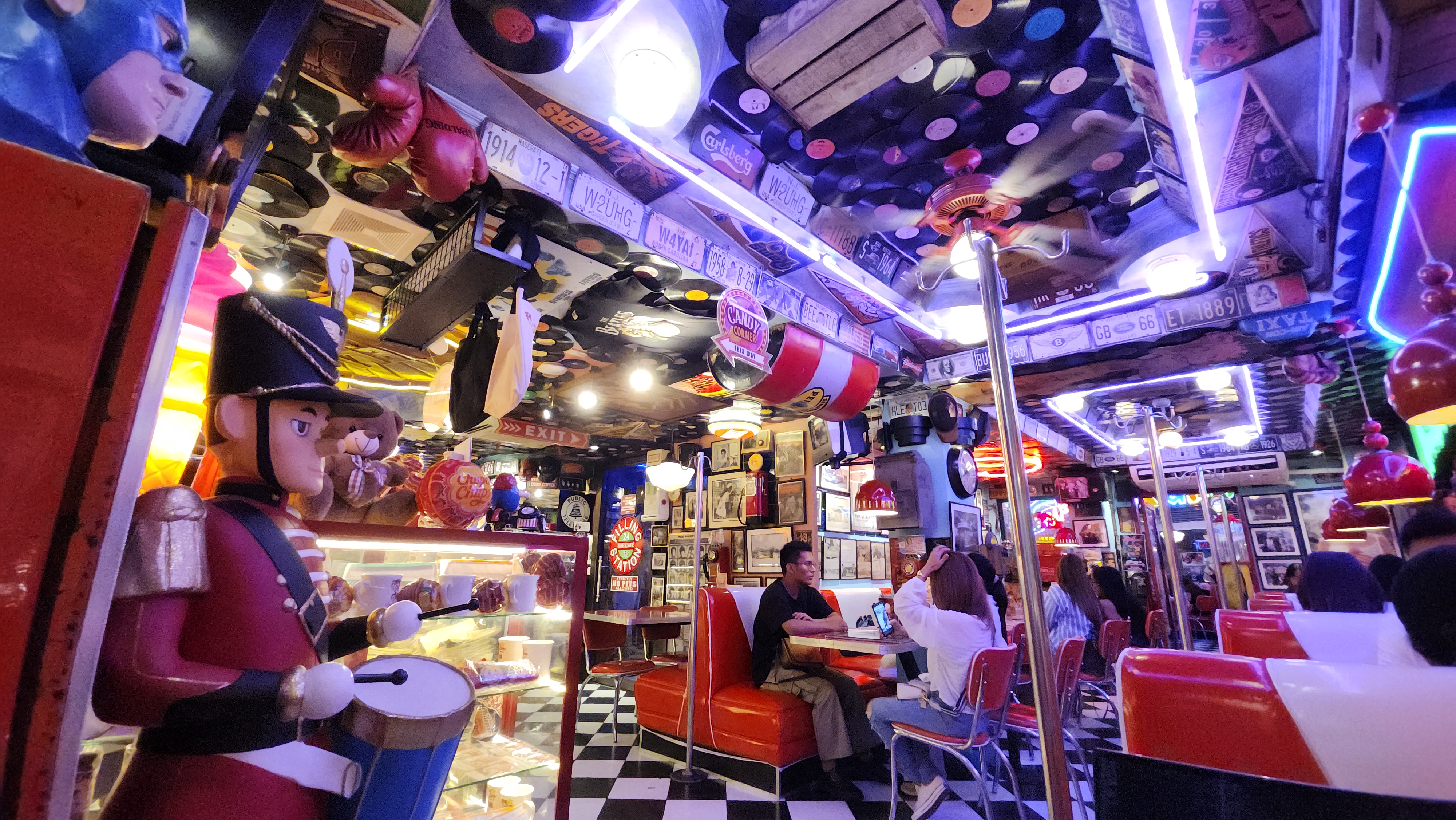 LP and other vinyl records, license plates, oil barrels, old advertising signs cover the ceiling and walls